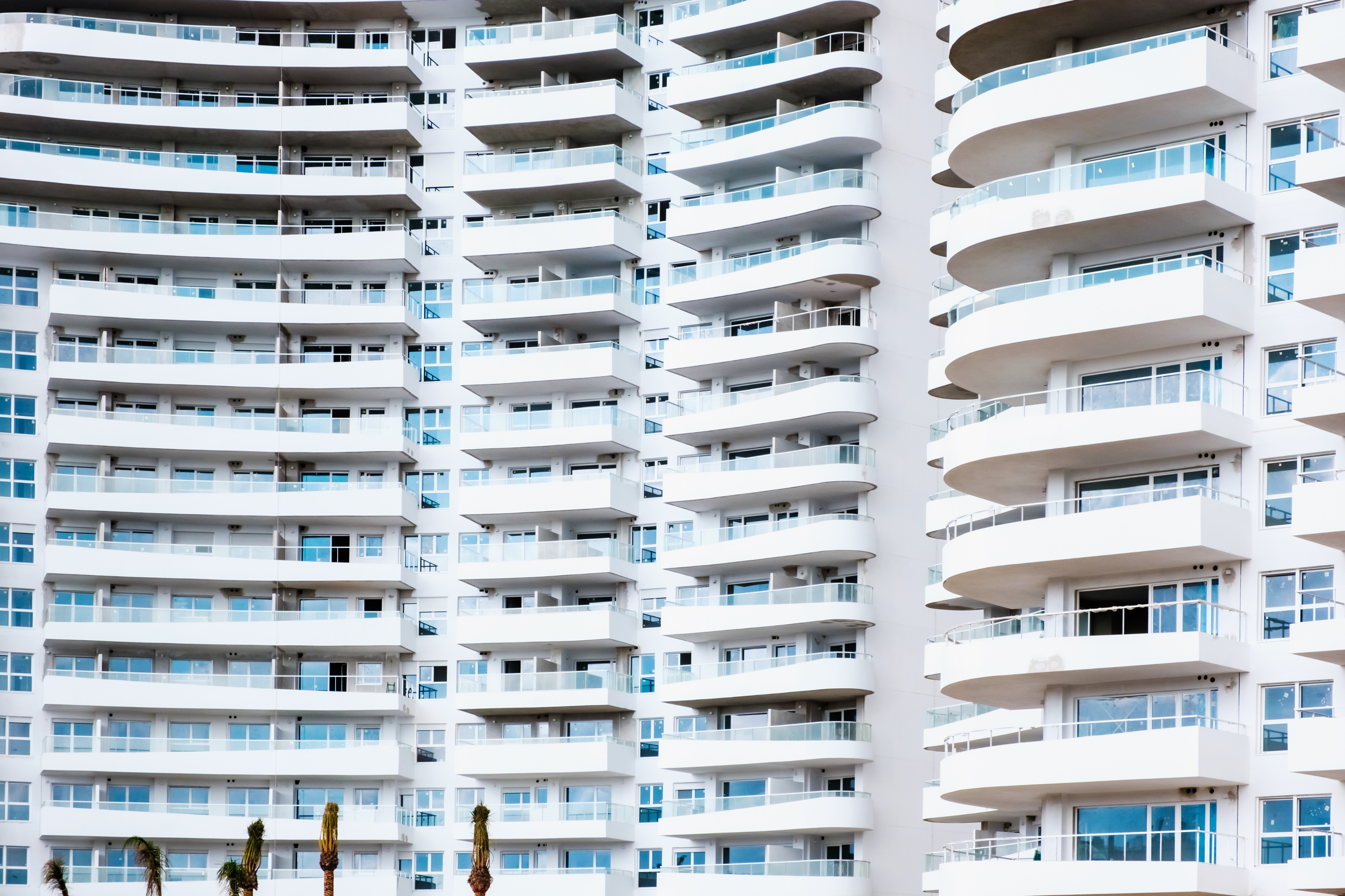Modern apartment buildings viewed from below against a blue sky