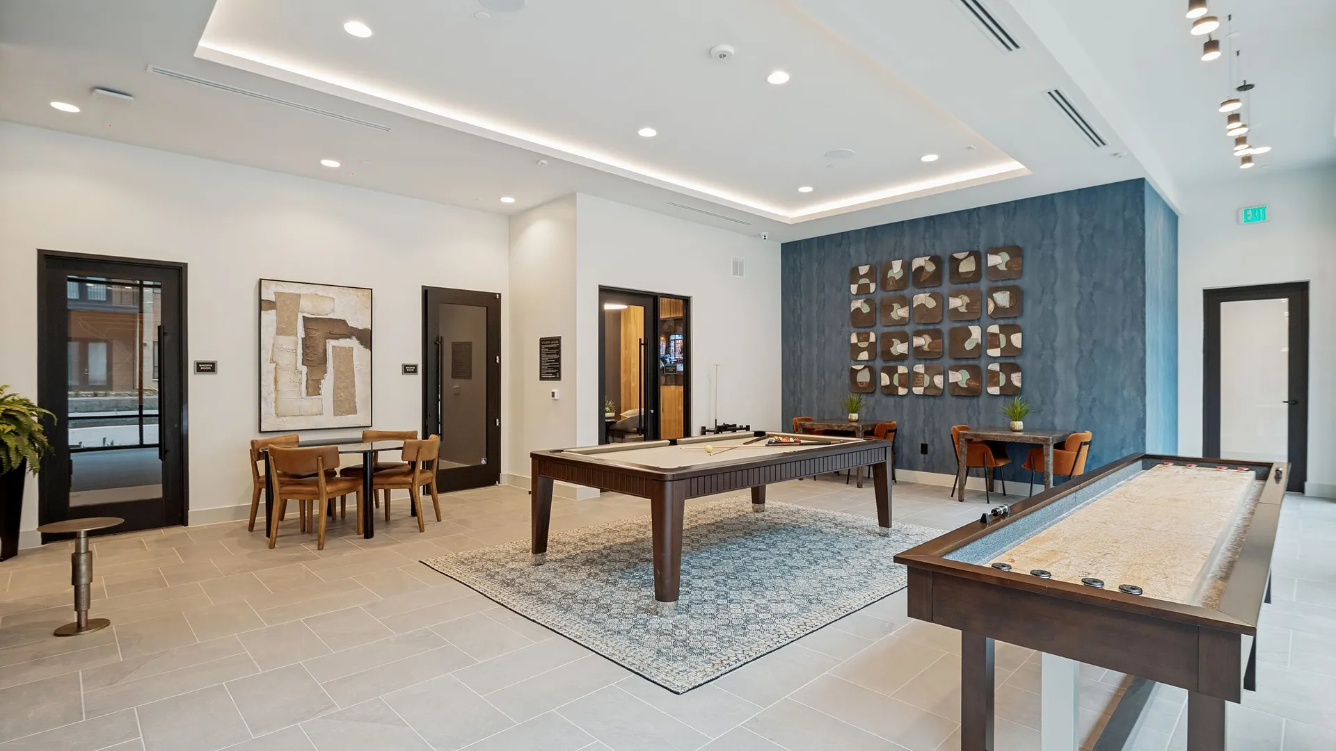 Modern lobby area featuring a shuffleboard table, dining space, and stylish decor.
