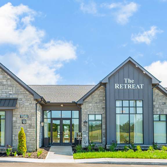 the retreat building with large windows and a blue sky