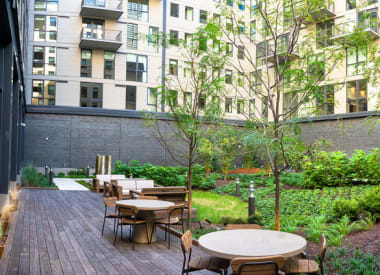 a patio with tables and chairs in a courtyard