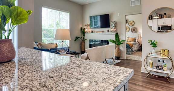 A living room with a large granite countertop and a television.