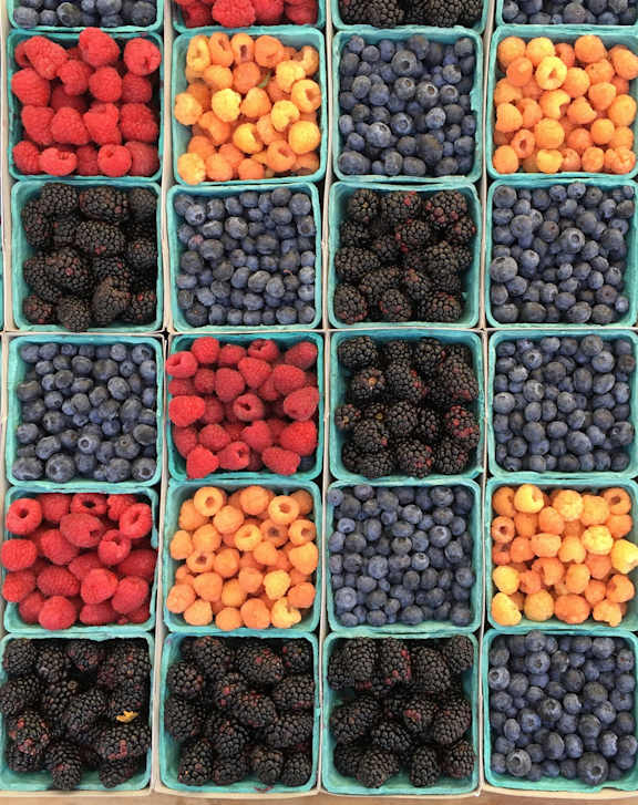 A display of berries in blue containers.