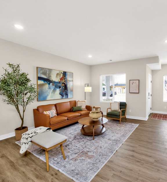 A living room with a sofa, chairs, a coffee table, and a television.