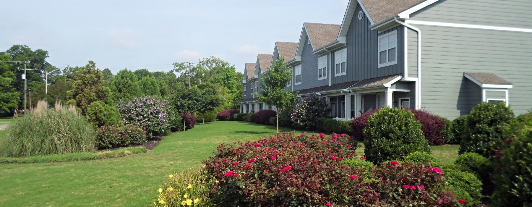 a house with a large lawn and a large flower bed