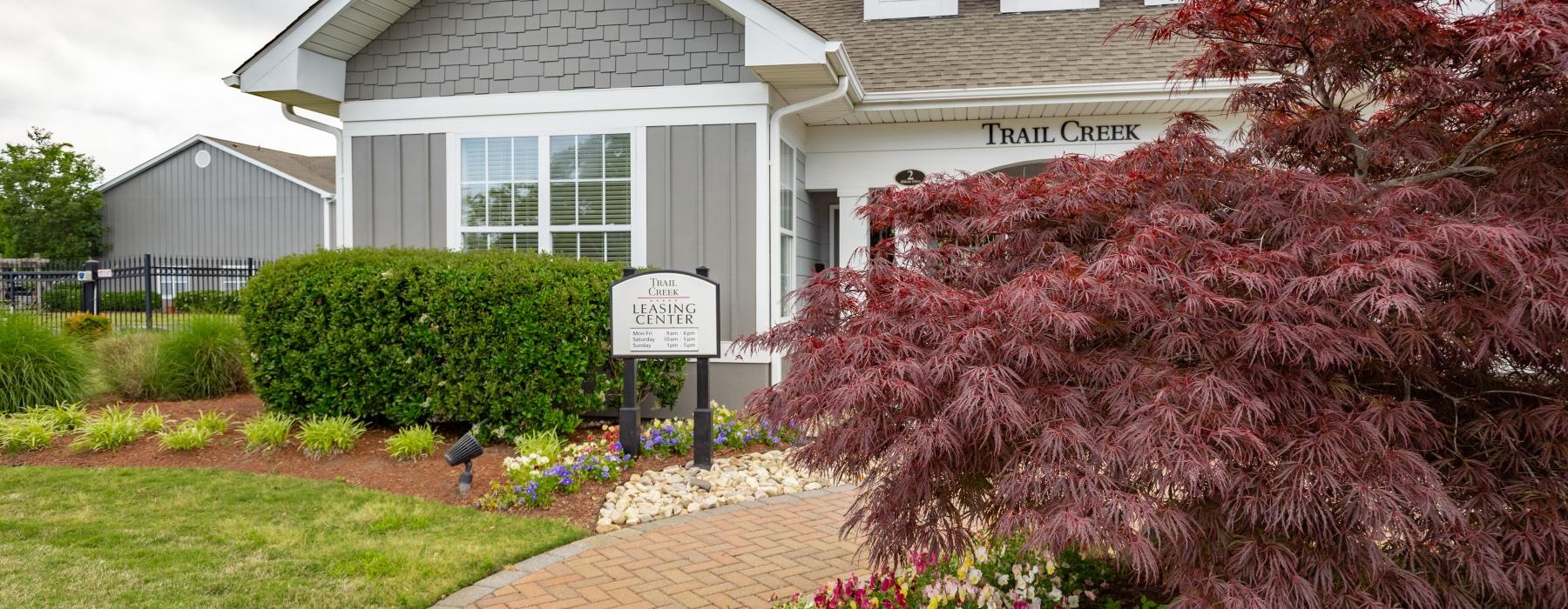 a house with a brick driveway and a brick path with a sign