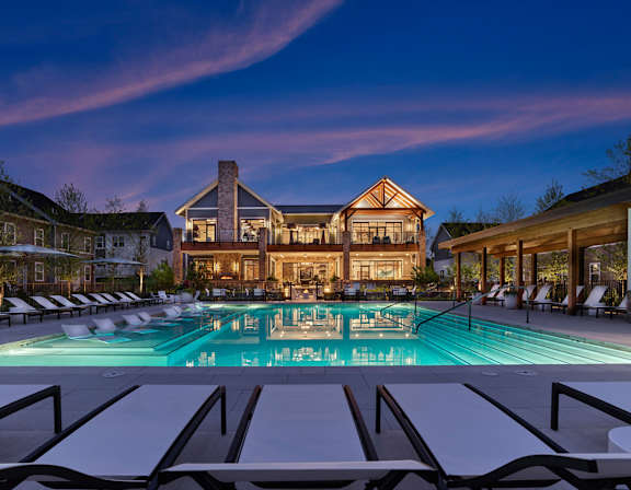 A large house with a pool in front of it.