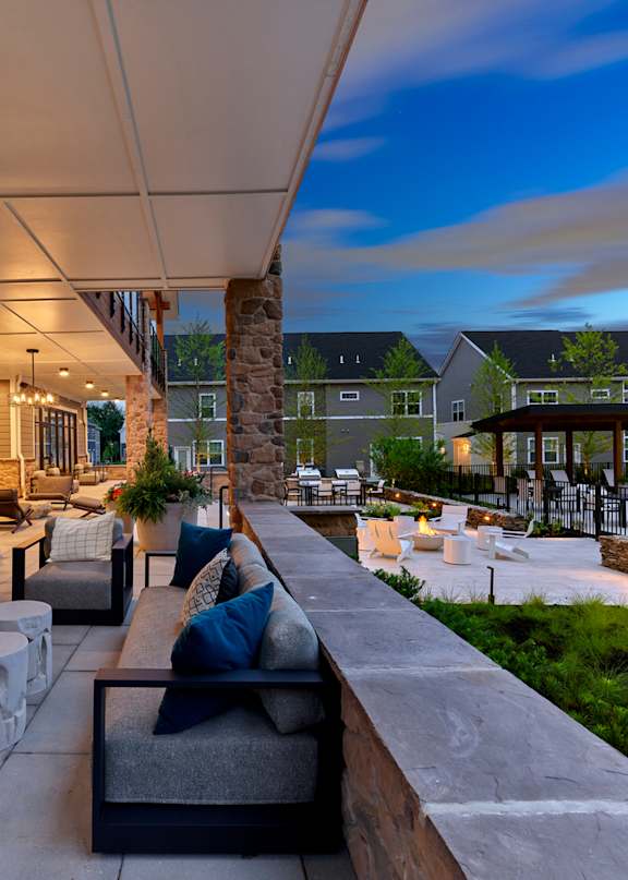 A patio with a stone fireplace and seating area.