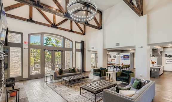 A large, open-concept living room with a high ceiling and wooden beams.