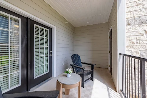 Cozy apartment balcony featuring two chairs and a small table, perfect for relaxing outdoors.