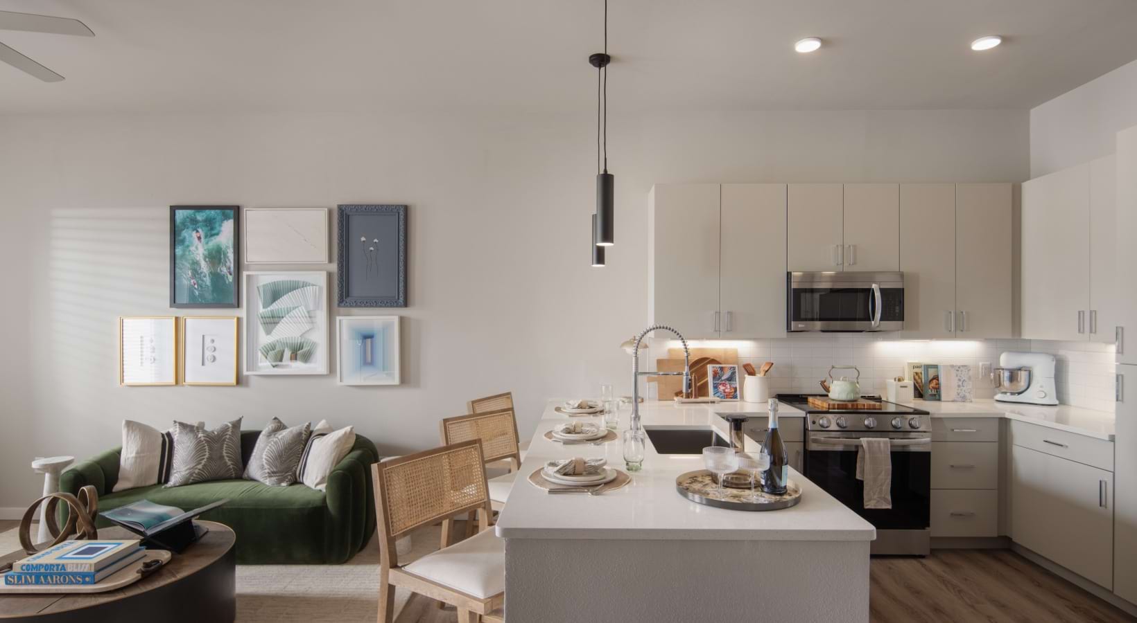 kitchen with counter seating open to living area with green couch and coffee table