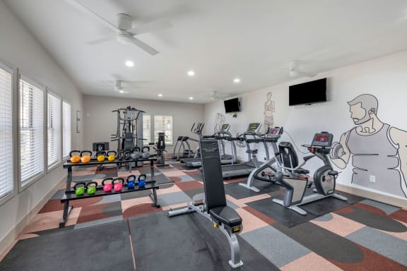 a home gym with exercise equipment and a wall mural of a man on the wall at Paisley and Pointe Apartments, Las Vegas, 89130