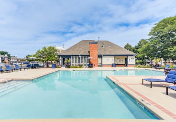 A large swimming pool with a building in the background.