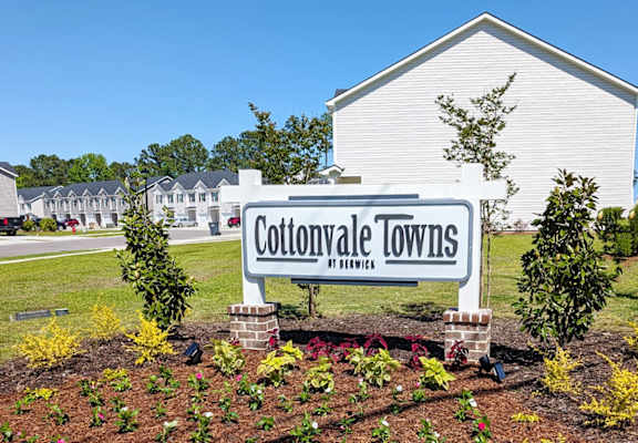A white building with a sign that says Cottonvale Towns in front of it.