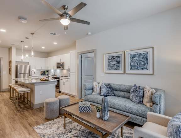 an open living room and kitchen with a ceiling fan