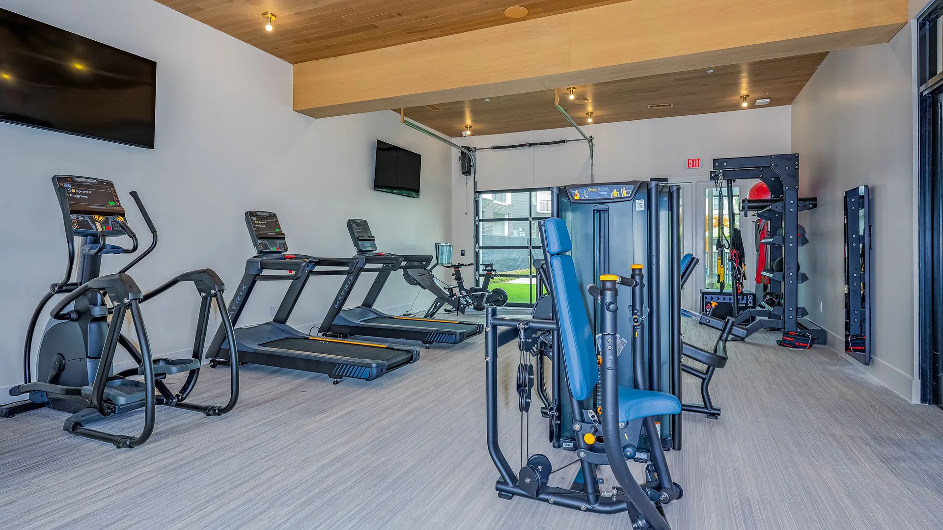 Bright, modern gym with various workout machines and equipment.