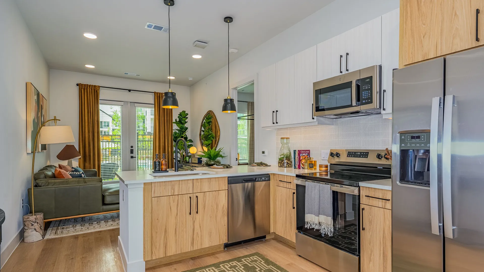 Modern kitchen with stainless steel appliances and open layout connected to living area.