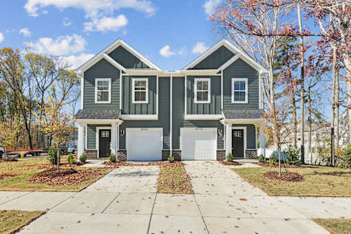 A two-story house with a garage and a driveway.