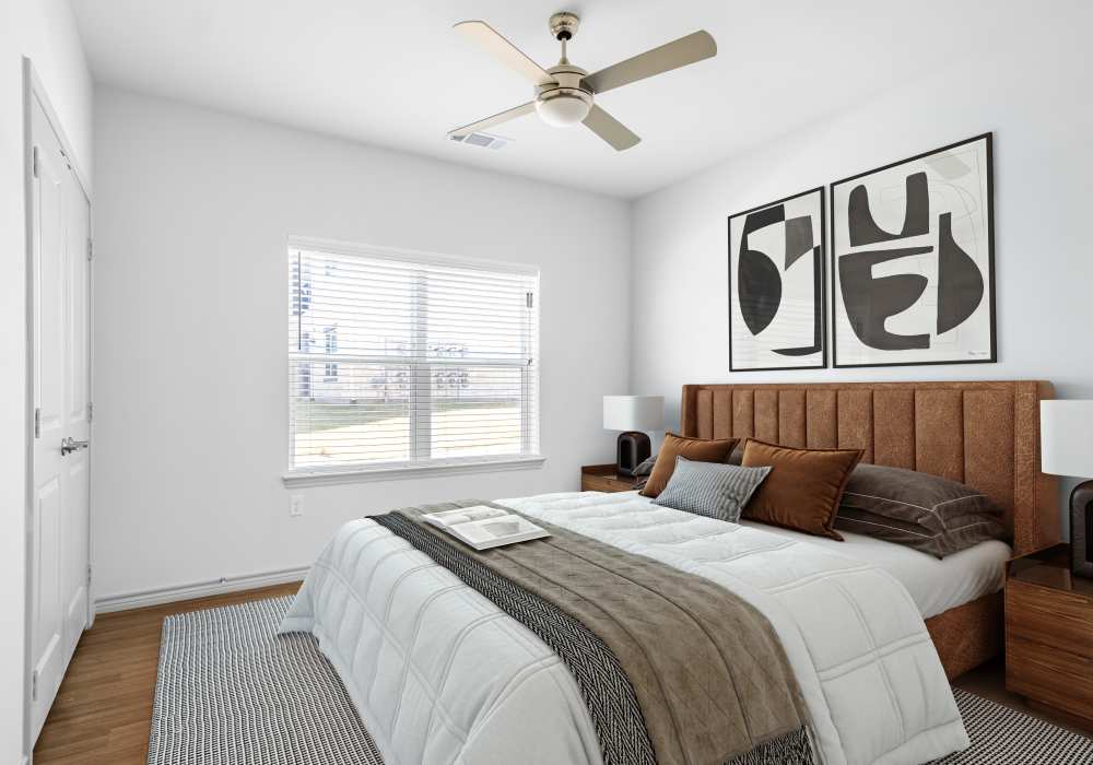 Model bedroom with wood-style flooring at Terrace at Southern Oaks in Dallas, Texas