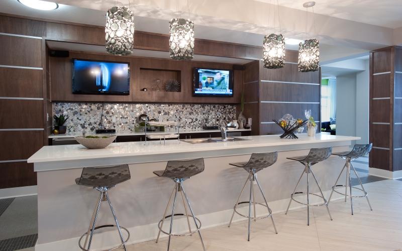 a lounge with a tv and stools