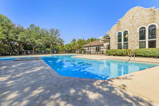 A large swimming pool in front of a house.