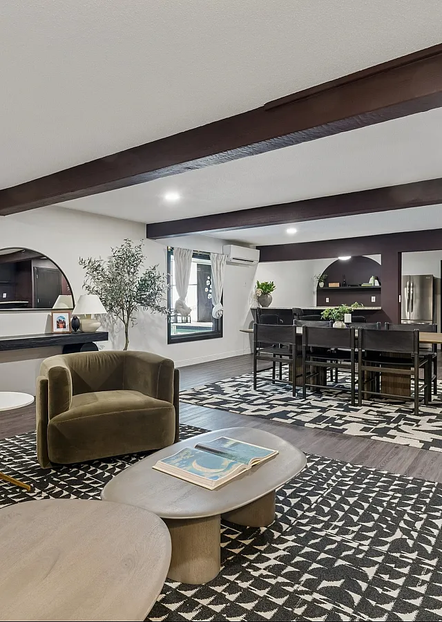 Sophisticated living area showcasing modern décor, earthy-toned armchairs, and an elegant dining setup under warm ambient lighting.