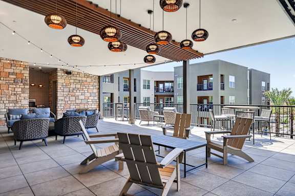 A patio with a table and chairs under a wooden beam.