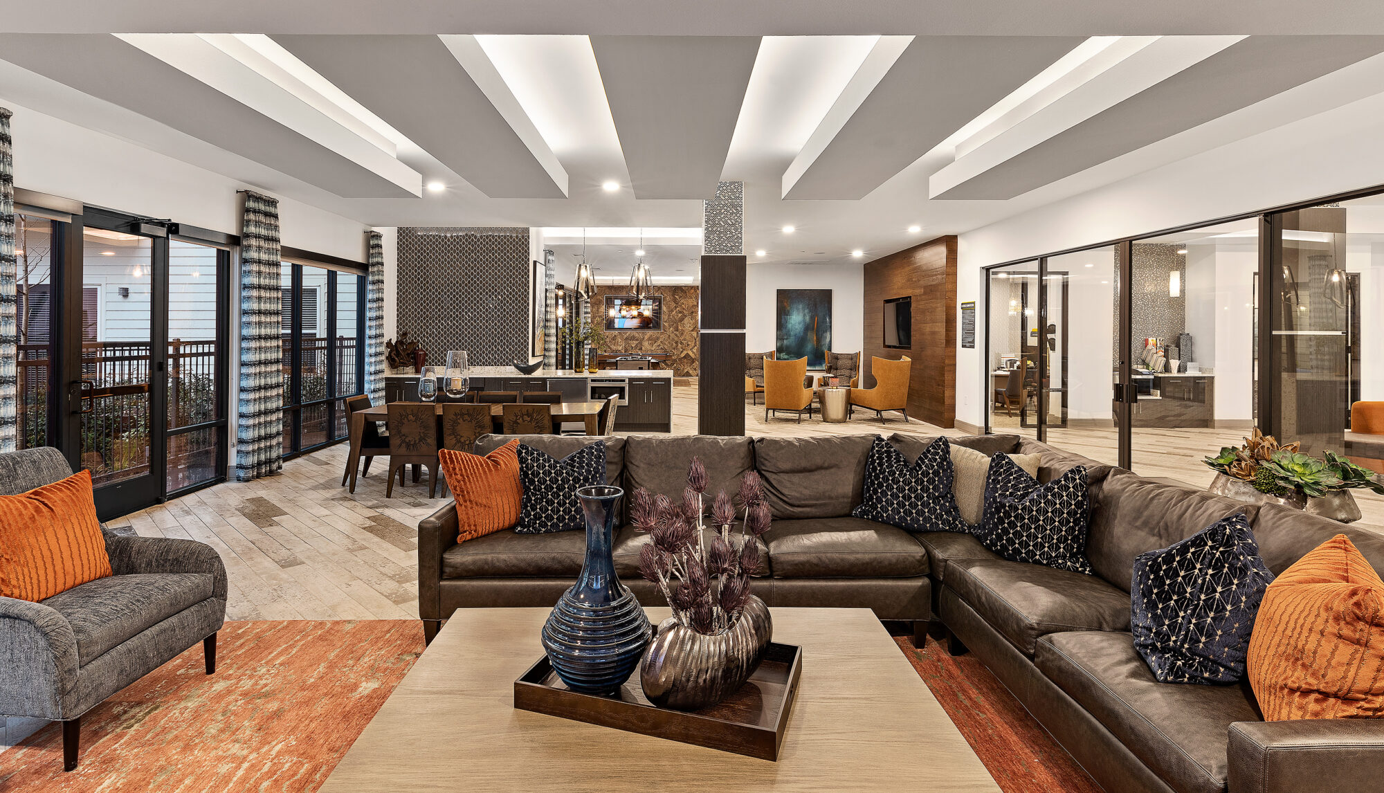 Clubhouse lounge with sofas, kitchen, and TVs