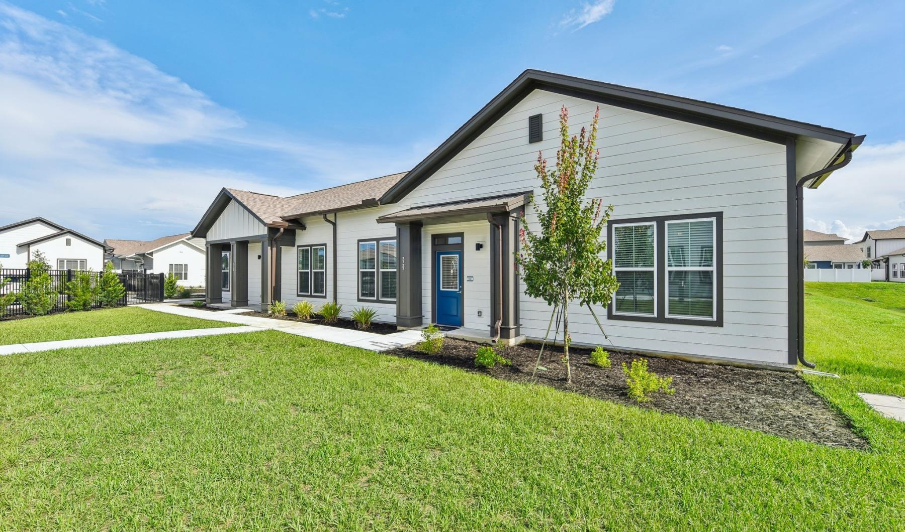 a house with a driveway and green lawn