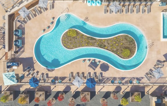 a hotel pool with umbrellas and chaise lounges