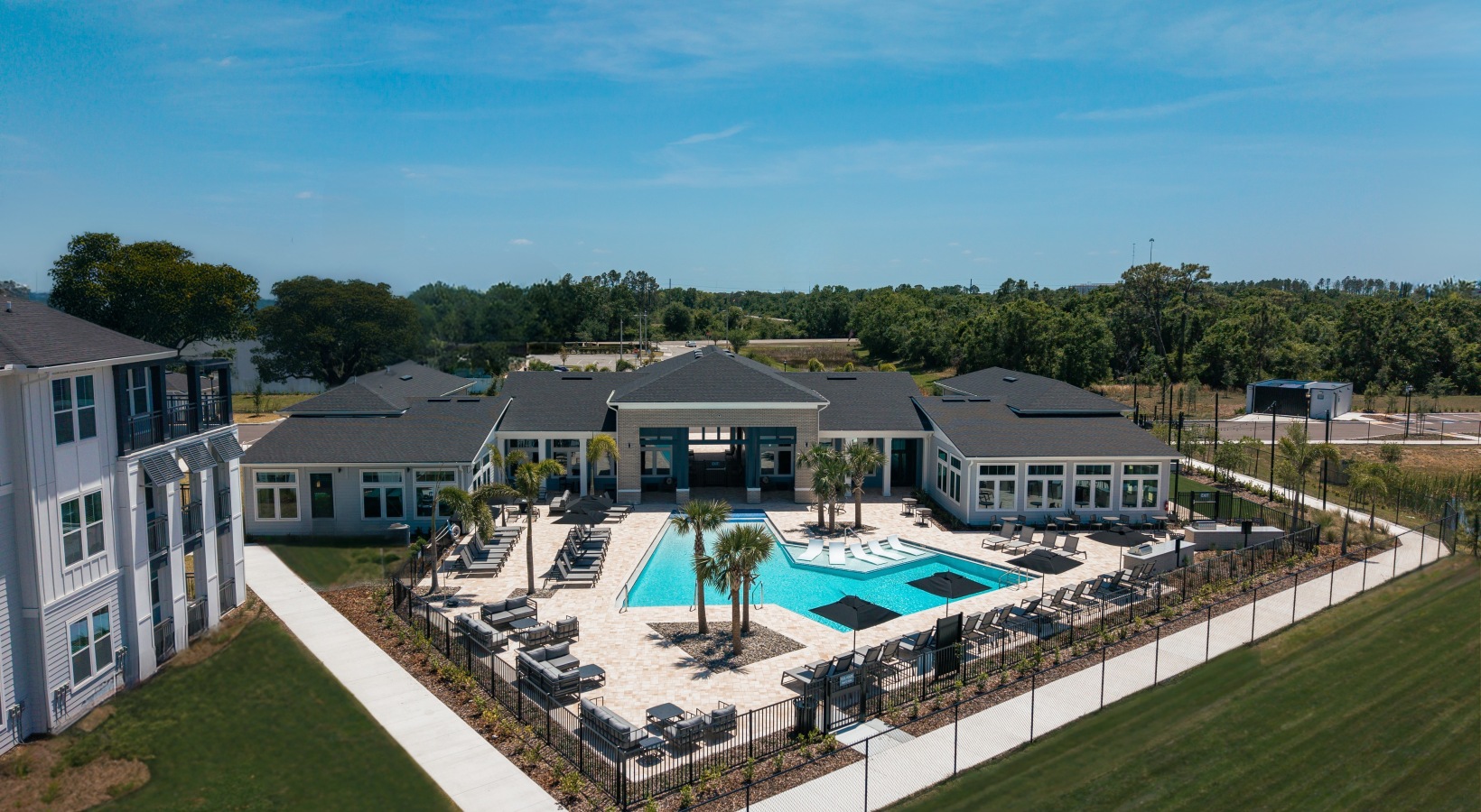 Outdoor resort-style pool at Madison Palms apartments in Ruskin FL with lounge seating and palm trees.