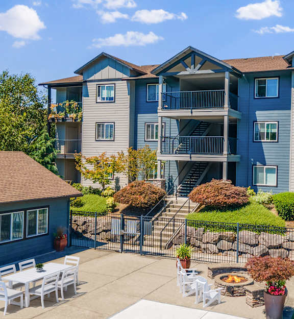 A large apartment complex with a patio and outdoor furniture.