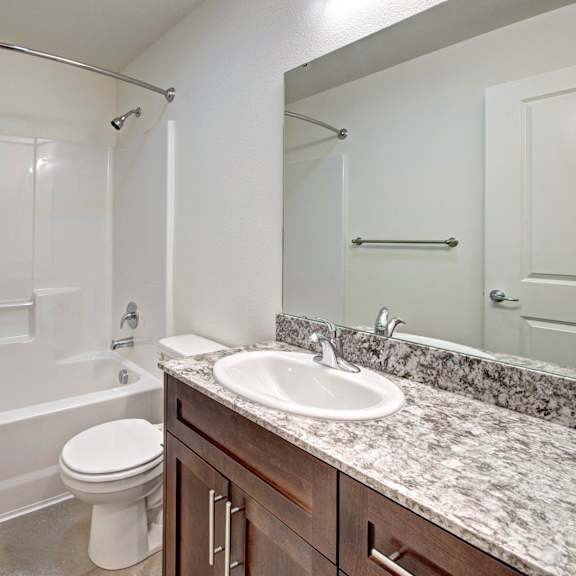 A white bathroom with a sink, toilet, and bathtub.