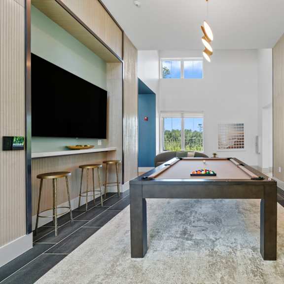 a pool table in a living room with a painting on the wall