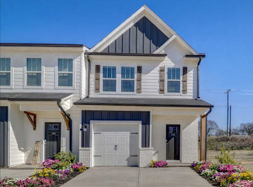 A two-story house with a garage and a front porch.