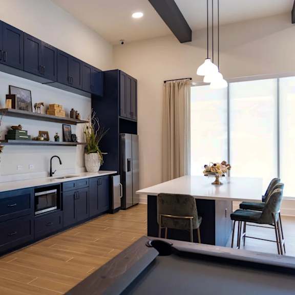 A modern kitchen with dark blue cabinets and a white countertop.