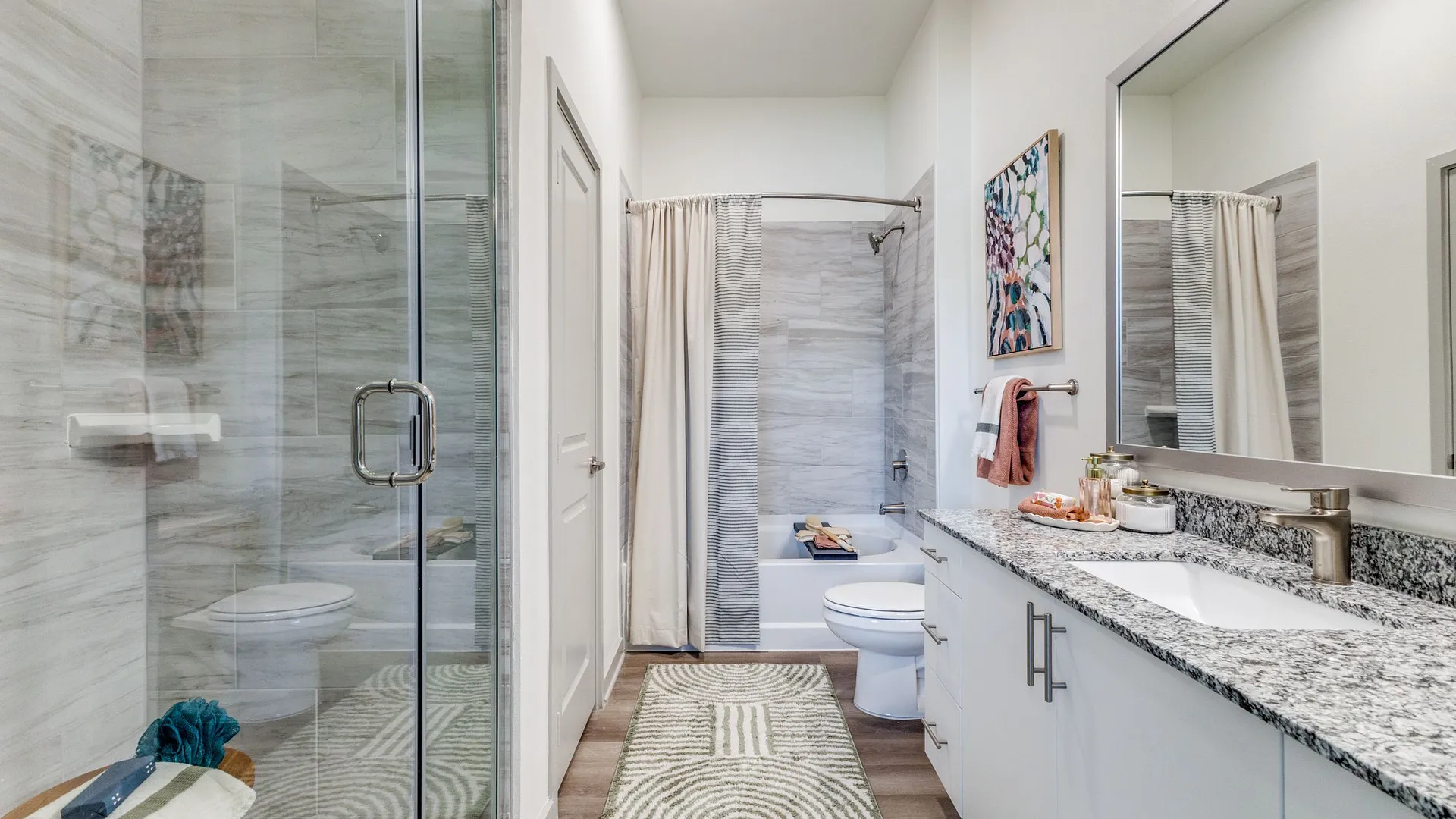 bathroom with glass shower, vanity, and bathtub