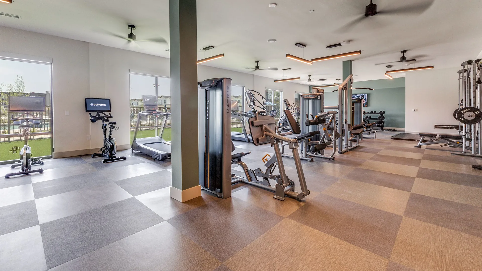 gym with workout equipment and large windows