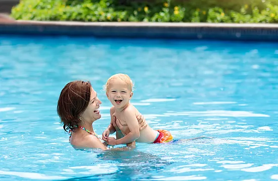 mom swimming with baby in a pool