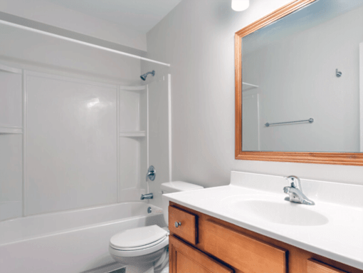 A white bathroom with a toilet, sink, and bathtub.