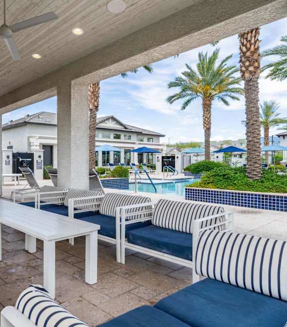 A patio with a white couch, a fireplace, and a television. at Vistoria At Stadium Apartments, Glendale, Arizona