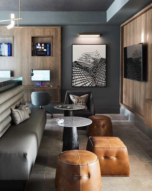 A modern living room with a grey sofa, a round table, and a TV.