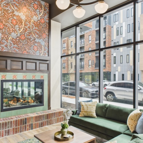 Clubhouse with wallpaper fireplace and green velvet couch