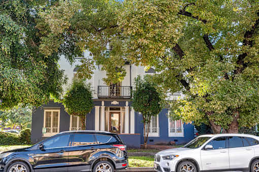 Two cars parked in front of a house.