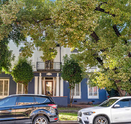 Two cars parked in front of a house.