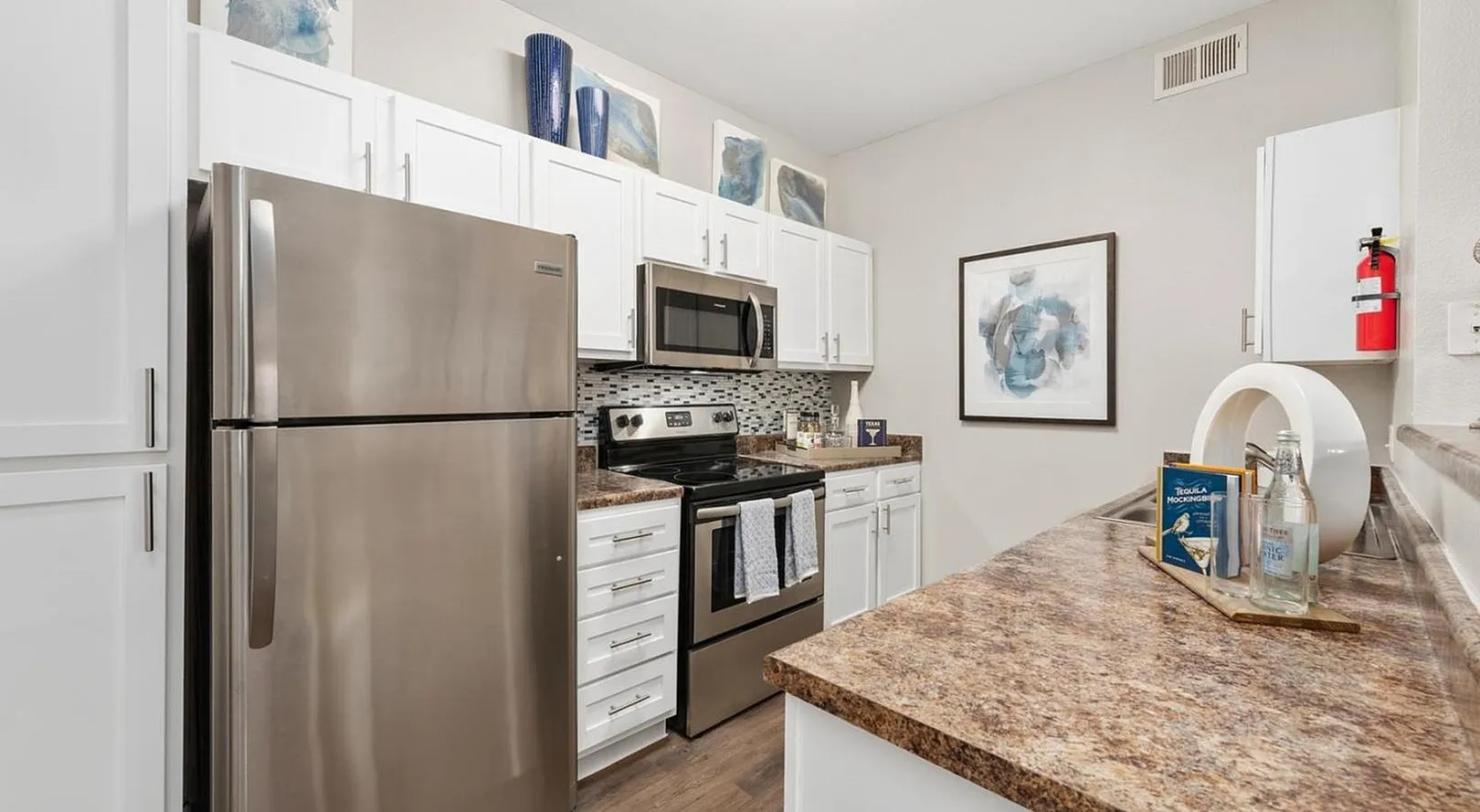 Modern kitchen with sleek stainless steel appliances, stylish backsplash, and elegant granite countertops.
