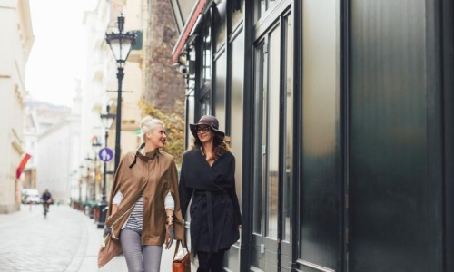 a couple of women walking down a sidewalk