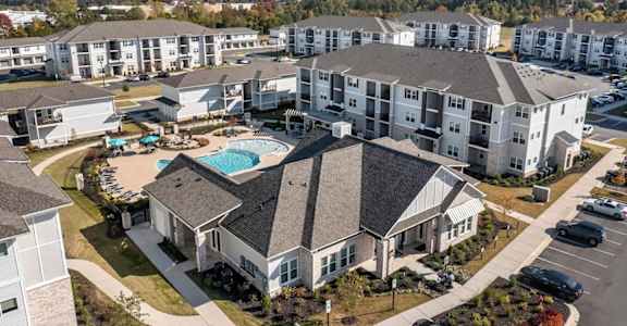 A large apartment complex with a swimming pool in the center.