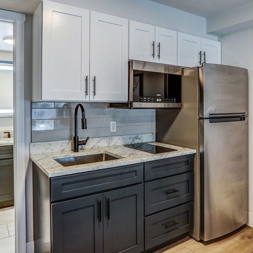 Modern studio kitchen at Dalton Station featuring stainless steel appliances, induction cooktop, and granite countertops in Dalton, GA.