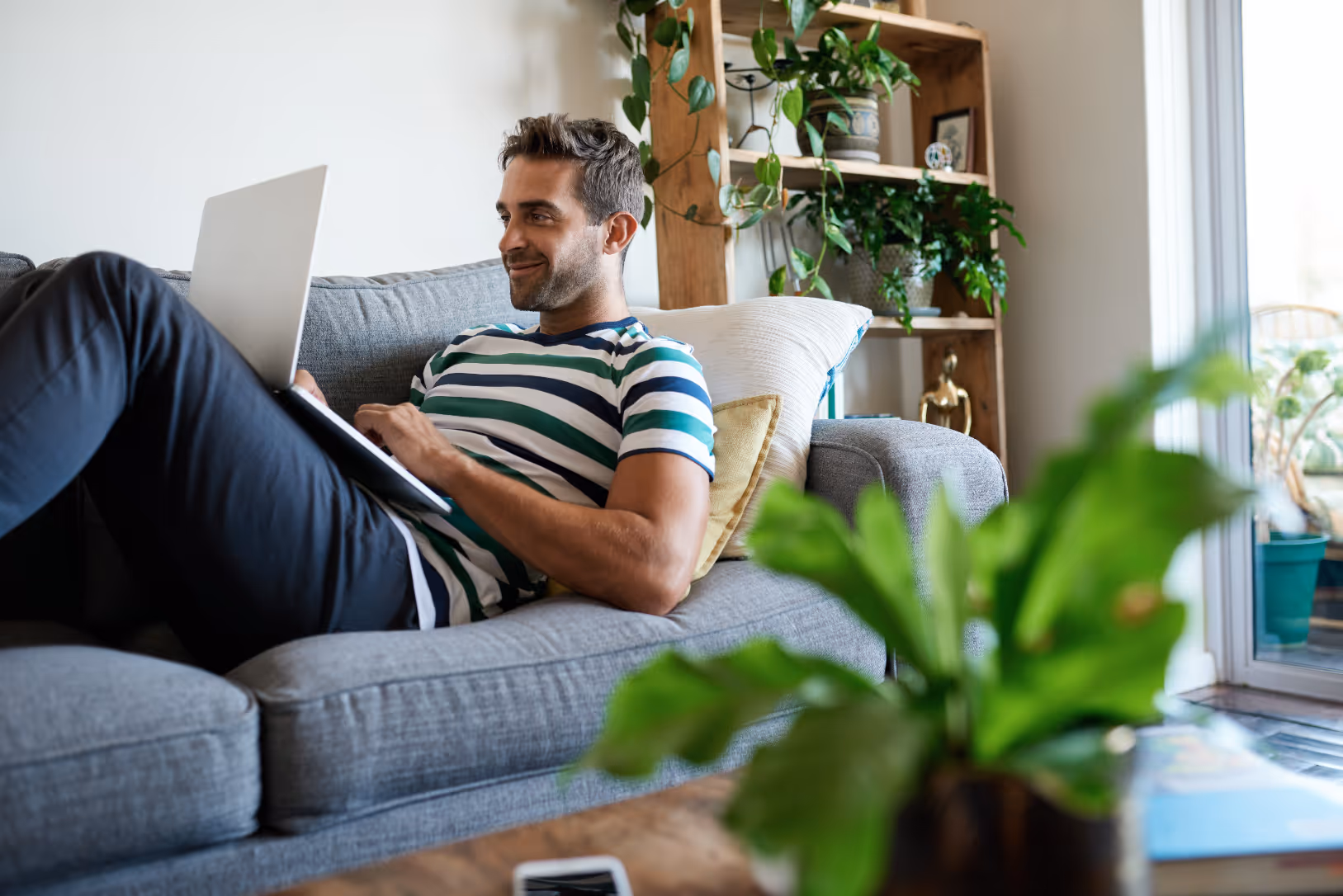 man on sofa with computer stock image