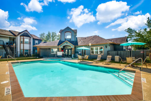 Pet-Friendly Apartments in Beaumont, TX – Breakwater Bay - swimming pool with umbrellas and beach chairs